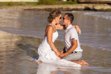 bir kum okyanus tarafından birlikte oturan genç Çift