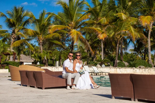 Young wedding couple sitting on the sunbed — Stok fotoğraf