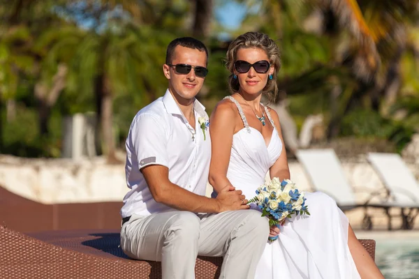 Young wedding couple sitting on the sunbed — Stok fotoğraf