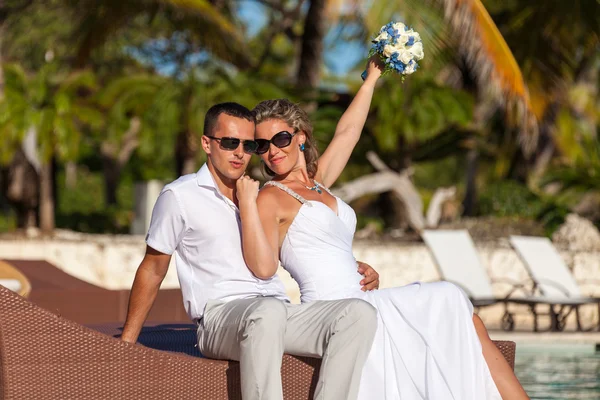 Junges Hochzeitspaar sitzt auf der Sonnenbank — Stockfoto