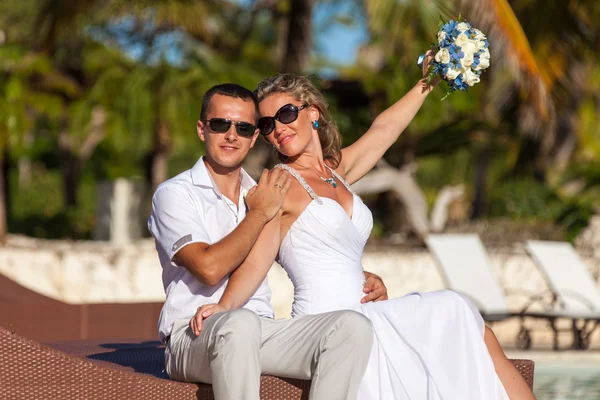 Young wedding couple sitting on the sunbed — Stock Photo, Image