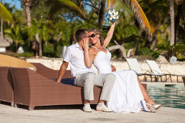 Young wedding couple sitting on the sunbed — Stock Photo, Image