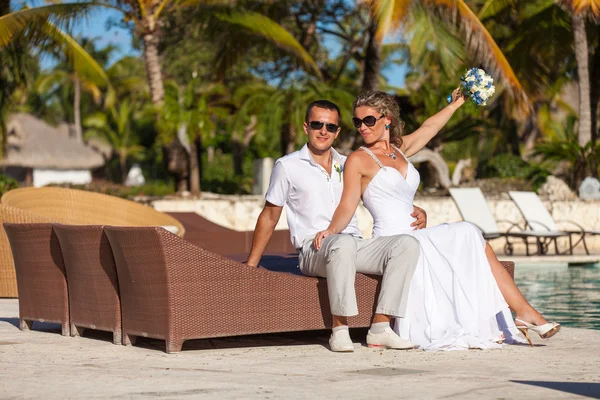 Young wedding couple sitting on the sunbed — ストック写真