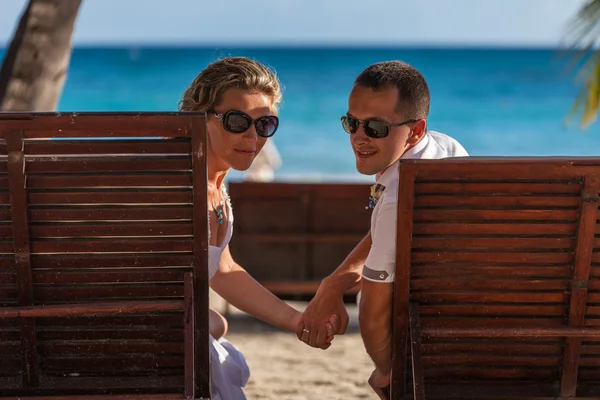 Young wedding couple lying on the sunbed — Stockfoto