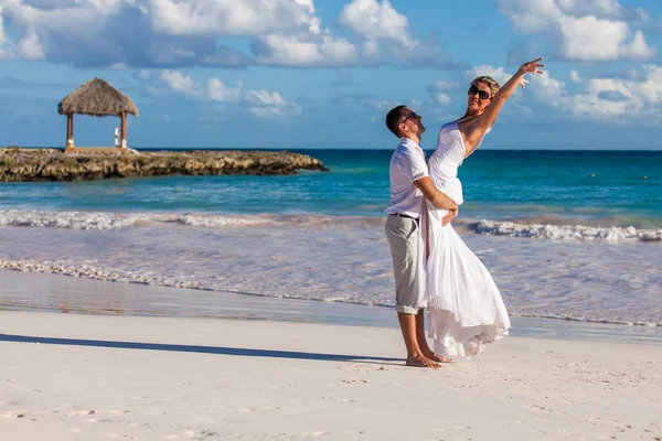 Le gars tient la fille sur les mains. Plage océanique — Photo