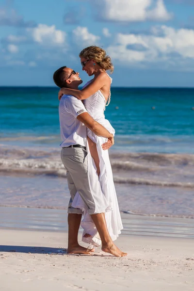 Guy holds girl on hands. Ocean beach — Stock Photo, Image