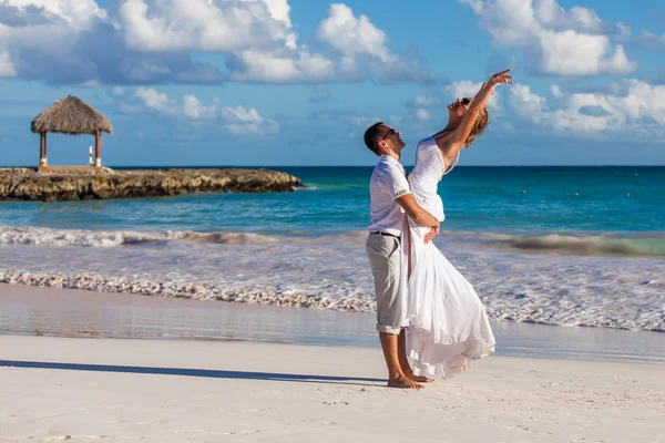 Парень держит девушку на руках. Морской пляж — стоковое фото