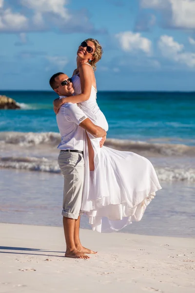 Guy holds girl on hands. Ocean beach — Stock Photo, Image