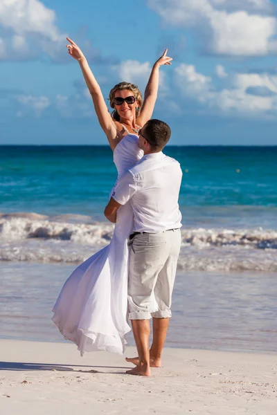 Guy holds girl on hands. Ocean beach — Stock Photo, Image