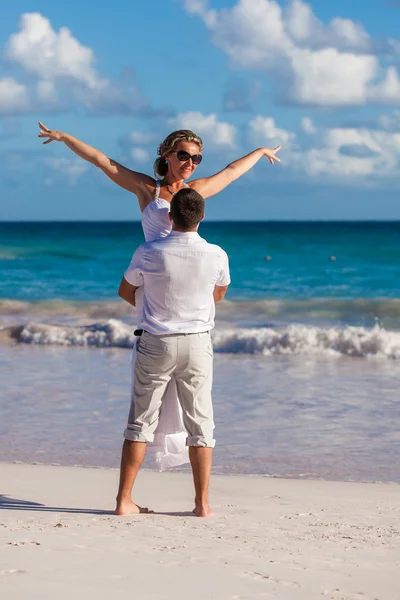 Ten drží dívku na rukou. Ocean beach — Stock fotografie