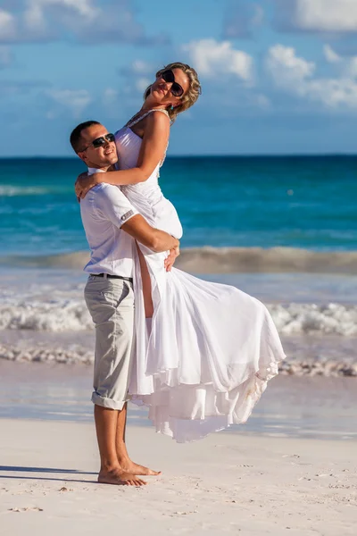 Guy holds girl on hands. Ocean beach — Stock Photo, Image