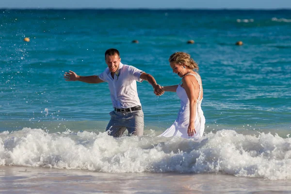 Young wedding couple have a fun in ocean waves — Stock Photo, Image