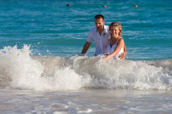 Young wedding couple have a fun in ocean waves — Stock Photo, Image
