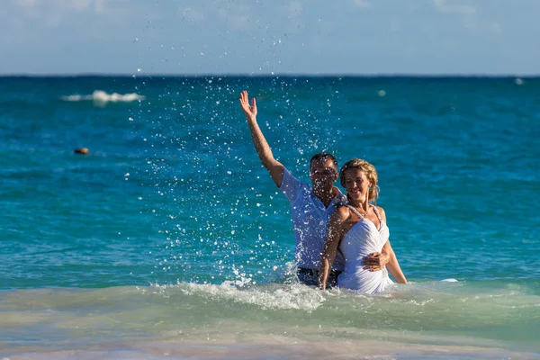 Casal jovem tem uma diversão em ondas do oceano — Fotografia de Stock