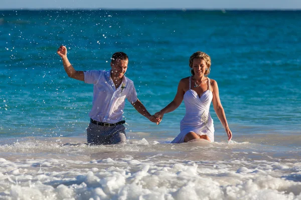 Casal jovem tem uma diversão em ondas do oceano — Fotografia de Stock