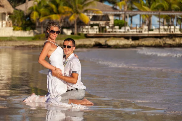 Junges Paar sitzt zusammen auf einem Sand am Meer — Stockfoto