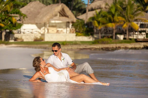 Young couple lie on the ocean beach — Stock Photo, Image