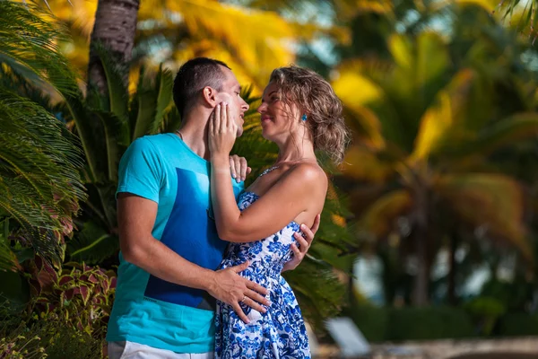 Ungt par på bakgrund av palmer — Stockfoto
