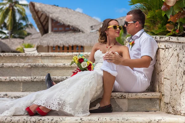 Bride and groom sitting on the steps — Stock Photo, Image