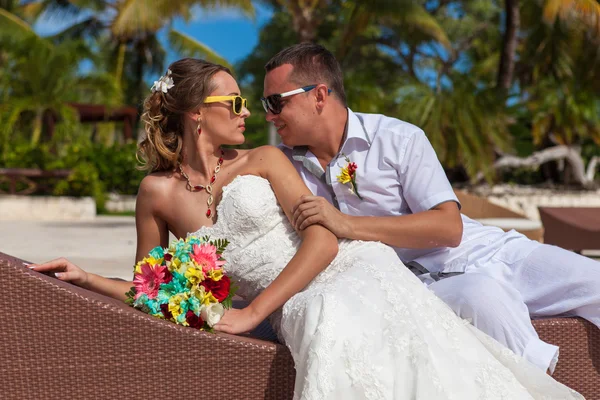 Man en vrouw ontspannen op de ligstoelen op het strand — Stockfoto