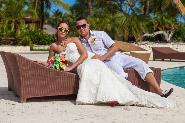 Husband and wife relaxing on sunbeds at the beach — Stock Photo, Image