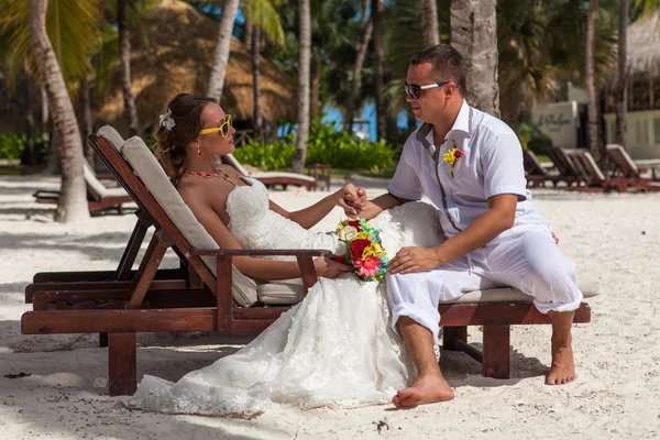 Marido y mujer relajándose en tumbonas en la playa —  Fotos de Stock