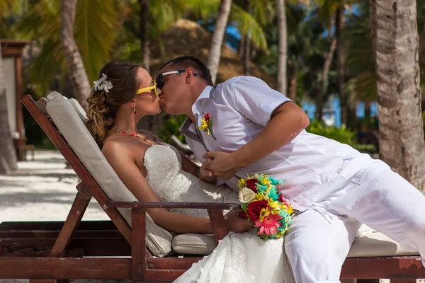 Marito e moglie si rilassano sui lettini in spiaggia — Foto Stock