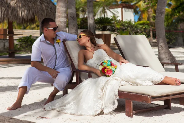 Mann und Frau relaxen auf Sonnenliegen am Strand — Stockfoto