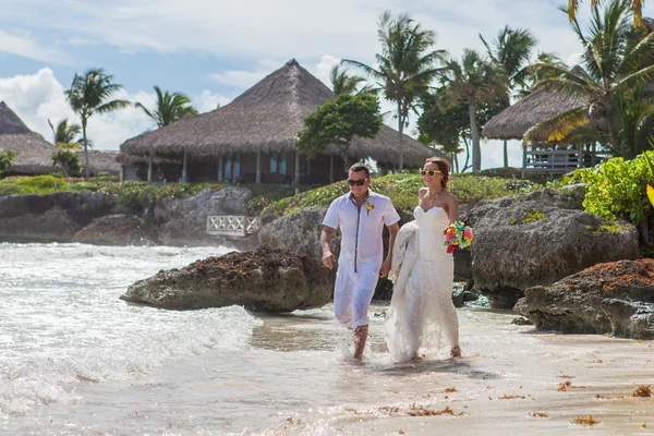 Couple courant à travers les vagues sur la plage vacances — Photo