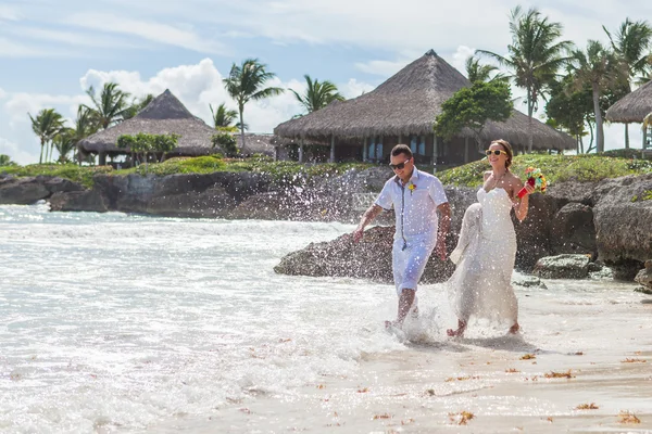 Couple courant à travers les vagues sur la plage vacances — Photo