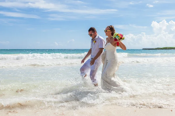 Пара бегущих по волнам на пляже отдыха — стоковое фото