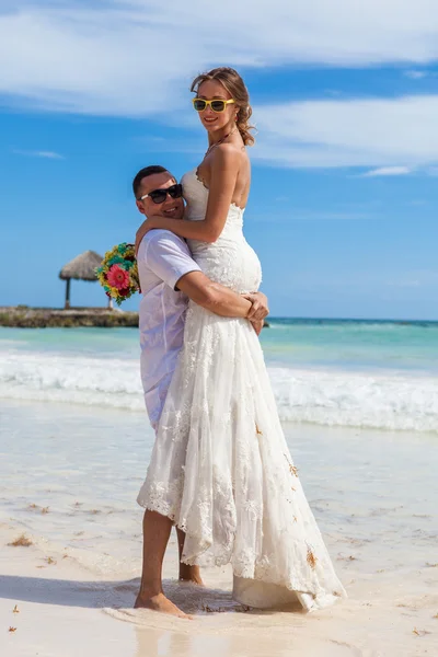 Guy holds girl on hands. Ocean beach — Stock Photo, Image