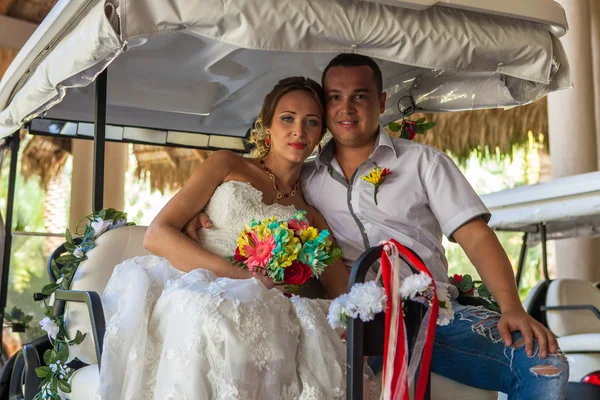 Novia y novio en la boda Día sentado en el coche de golf — Foto de Stock