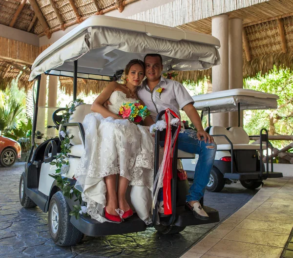 Bride and groom at wedding Day sitting in golf car — Stock Photo, Image