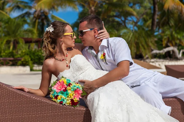 Муж и жена отдыхают на шезлонгах на пляже Лицензионные Стоковые Изображения