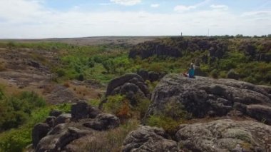 Anteni: lotus pozisyonu kayaya oturan kadın