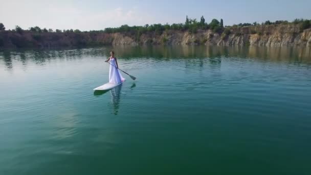 Aerial: young bride boarding SUP — Stock Video