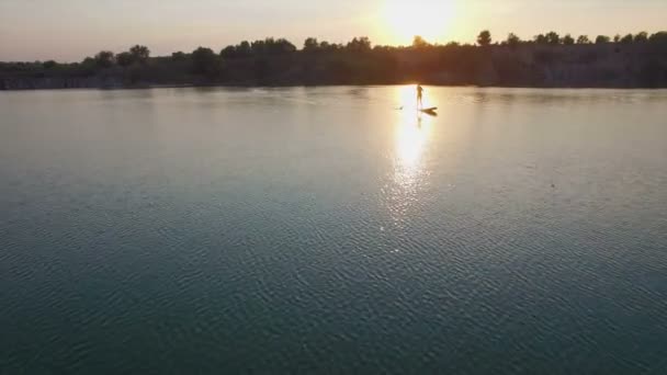 Aerial: young girl boarding SUP — Stock Video