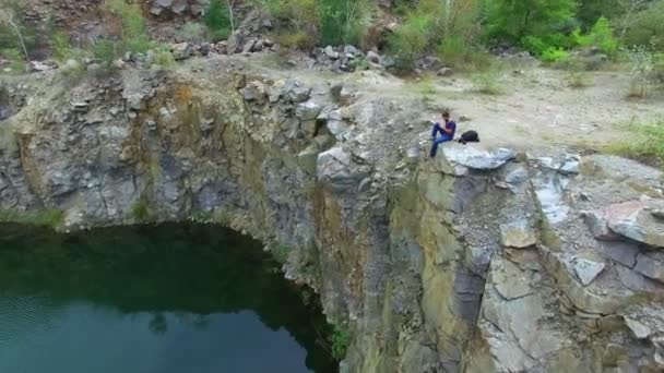 Aerial: Homem tira fotos no pico do rock — Vídeo de Stock