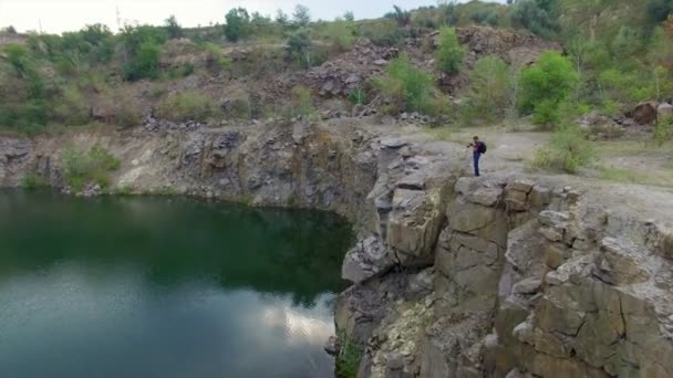 Aerial: Homem tira fotos no pico do rock — Vídeo de Stock