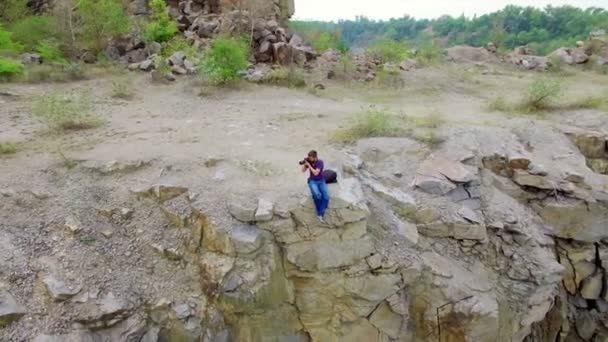 Aerial: Homem tira fotos no pico do rock — Vídeo de Stock