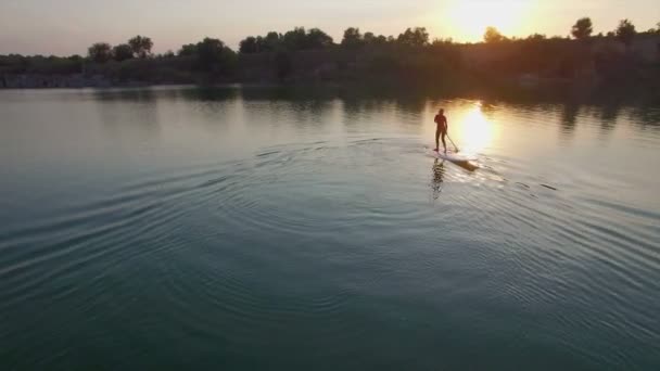 Aerial: young girl boarding SUP — Stock Video