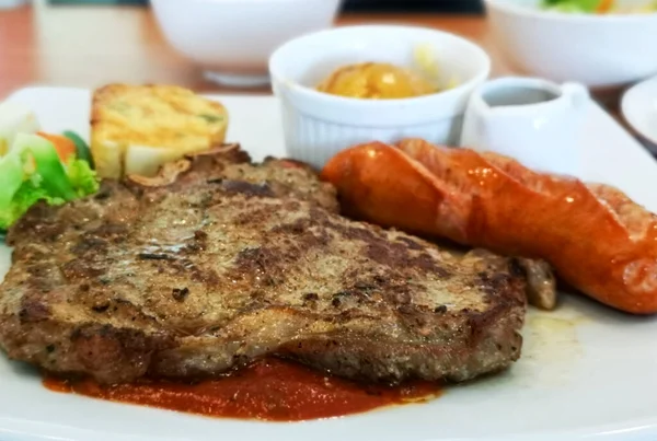 Çıtır sosisli biftek, patates püresi ve domates soslu sarımsaklı ekmek..