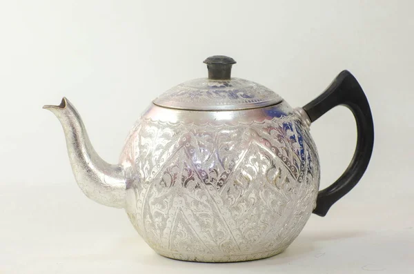 Beyaz arkaplan ve desen üzerine oyulmuş alüminyum kap.