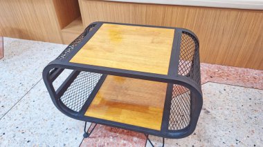 Modern iç dekorasyon alanları için ahşap paneller ve metal örgüleri birleştiren kompakt endüstriyel sehpa..