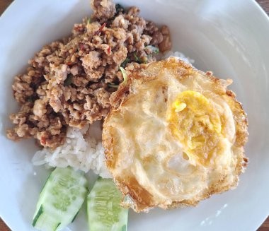 Geleneksel Tayland sokak yemekleri, baharatlı fesleğen kıymalı domuz eti buğulanmış pirinç ve kızarmış yumurta ile servis edilir..