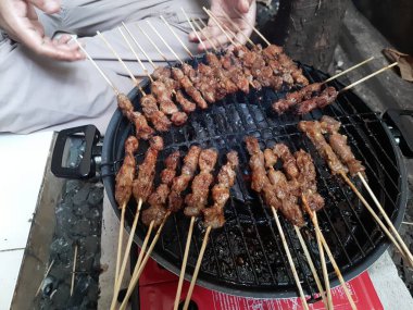 Kömür ocağında Satay pişiriyorum. Fırında ızgara tavuk çubuğu. Kömür ocağında Satay pişiriyorum. Fırında ızgara tavuk çubuğu. Satay ya da sate, Güneydoğu Asya 'nın en sevdiği sokak yemekleri, fıstık sosuyla servis edilir.  