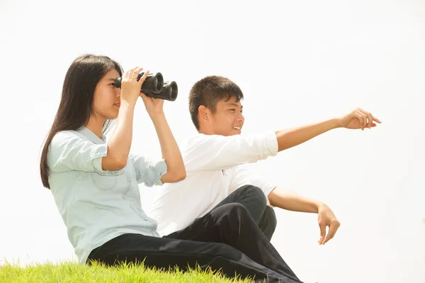 Asiatisk ung pojke och flicka sitta på högen söker kikare . — Stockfoto