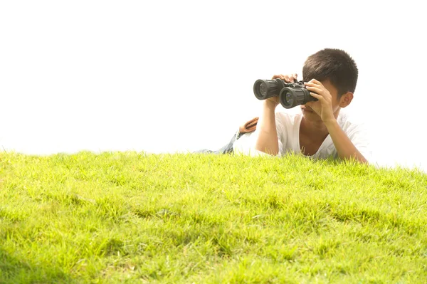 Ásia jovem menino mentira monte procurando binóculos  . — Fotografia de Stock