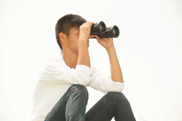 Asiatisk ung pojke sitter söker kikare . — Stockfoto